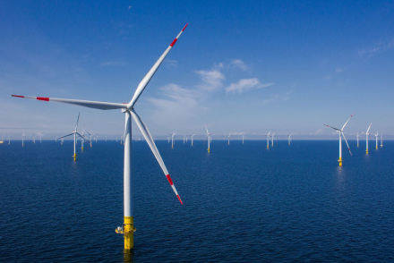 Offshore wind turbines in the ocean under a clear sky