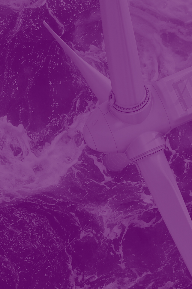 Aerial view of white offshore wind turbine blades over dark green ocean with waves and foam